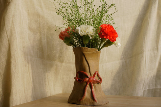 Brown paper vase with a ribbon bow